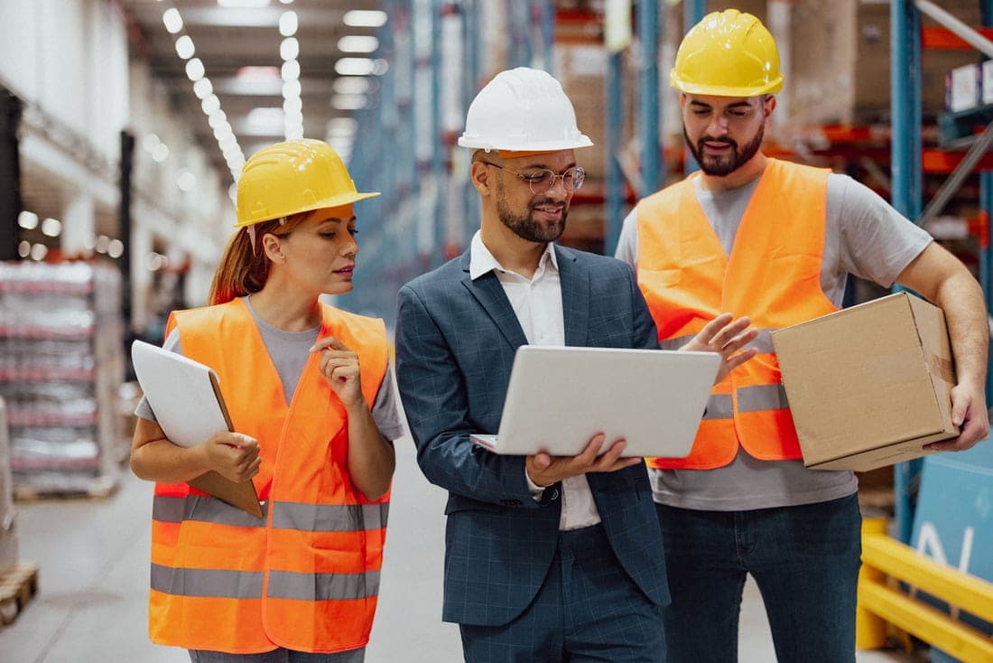A Guide to Ecommerce for Manufacturers Distributors using digital tablet to discuss business logistics, signifying success with ecommerce platform for manufacturers